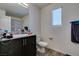 Bathroom featuring a dark vanity, granite countertop, toilet, and window at 2598 Mocha Pearl Ct, North Las Vegas, NV 89086