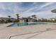 Community pool with clear water, palm trees, lounge chairs, and umbrellas at 2598 Mocha Pearl Ct, North Las Vegas, NV 89086