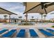 Spacious pool with lounge chairs, shade umbrellas, desert landscape, and palm trees at 2598 Mocha Pearl Ct, North Las Vegas, NV 89086