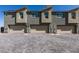 Townhome garages with brick paved driveway, neutral paint colors, and gable style roofing at 2598 Mocha Pearl Ct, North Las Vegas, NV 89086