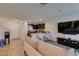 Open concept living room featuring a cozy couch, kitchen view, and modern entertainment center at 2598 Mocha Pearl Ct, North Las Vegas, NV 89086