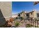 Relaxing patio view with wooden chairs and a black metal fence overlooking the community and scenic mountains at 2598 Mocha Pearl Ct, North Las Vegas, NV 89086
