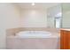 A white jacuzzi tub with gold hardware is surrounded by a beige tile surround at 2747 Paradise Rd # 1706, Las Vegas, NV 89109