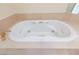 A white jacuzzi tub with gold hardware is surrounded by a beige tile surround at 2747 Paradise Rd # 1706, Las Vegas, NV 89109