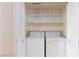 A laundry closet has a stackable white washer and dryer with white shelving above at 2747 Paradise Rd # 1706, Las Vegas, NV 89109