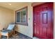Charming front entrance featuring a brick-paved porch, red door, and a cozy seating area by a large window at 2773 Chetco River St, Laughlin, NV 89029