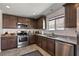 Well-lit kitchen featuring modern appliances, granite countertops, and dark wood cabinets at 2773 Chetco River St, Laughlin, NV 89029