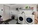 Practical laundry area with white washer and dryer, and overhead shelving at 2773 Chetco River St, Laughlin, NV 89029