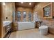 Bright bathroom featuring modern vanity, soaking tub, and wood-paneled walls at 306 Crestview Dr, Las Vegas, NV 89124