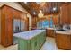 Open concept kitchen with wooden cabinetry, stainless steel appliances, and a unique island with marble countertops at 306 Crestview Dr, Las Vegas, NV 89124