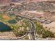 An aerial showcases the community layout including roads, ponds, desert landscapes, and varied home styles at 33 Via Di Mello, Henderson, NV 89011
