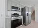 Well-equipped kitchen boasting stainless steel appliances and sleek, gray cabinetry at 3541 Arcadian Sea St, Las Vegas, NV 89106