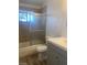 Updated bathroom features modern vanity, shower-tub combination with tiled surround and sliding glass doors at 4300 Don Quixote St, Las Vegas, NV 89121