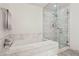 Luxurious bathroom featuring marble tiling, a soaking tub, and a glass-enclosed shower at 4471 Dean Martin Dr # 2605, Las Vegas, NV 89103