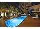 Long swimming pool with inviting blue light surrounded by comfortable seating at night at 4471 Dean Martin Dr # 2605, Las Vegas, NV 89103