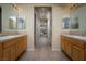 Bathroom with double vanities, large mirrors, and ample cabinet space with hallway view between the sinks at 504 Pinnacle Heights Ln, Las Vegas, NV 89144