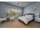 Light and airy bedroom with large windows, a stylish wicker bed, and soft blue walls at 504 Pinnacle Heights Ln, Las Vegas, NV 89144