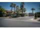 View of the gated entrance to a luxurious community with mature trees and landscaping at 504 Pinnacle Heights Ln, Las Vegas, NV 89144