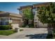 A front view of a stucco home featuring multi-car garage, manicured lawn, and mature trees at 504 Pinnacle Heights Ln, Las Vegas, NV 89144