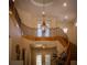 Elegant foyer with a curved staircase, iron railing, and a decorative light fixture creating a grand entrance at 504 Pinnacle Heights Ln, Las Vegas, NV 89144