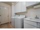 Functional laundry room with white cabinets, modern washer and dryer, and a sink with counter space at 504 Pinnacle Heights Ln, Las Vegas, NV 89144