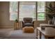 Cozy living room featuring a comfortable chair, stylish ottoman, and natural light filtering through the window blinds at 504 Pinnacle Heights Ln, Las Vegas, NV 89144