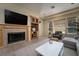 Cozy living room featuring a fireplace, built-in shelving, and a comfortable seating arrangement near the windows at 504 Pinnacle Heights Ln, Las Vegas, NV 89144
