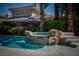 Backyard pool and rock waterfall feature lush plants, creating a private oasis at 504 Pinnacle Heights Ln, Las Vegas, NV 89144
