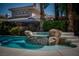 Inviting backyard pool with a rock waterfall feature and lush landscaping, perfect for relaxation and outdoor entertaining at 504 Pinnacle Heights Ln, Las Vegas, NV 89144
