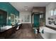 Elegant bathroom featuring dual vanities, a soaking tub, a glass-enclosed shower, and eye-catching teal tile accents at 5725 N Conquistador St, Las Vegas, NV 89149