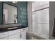Chic bathroom with floating vanity, a stylish mirror, and a glass-enclosed shower, all enhanced by modern fixtures at 5725 N Conquistador St, Las Vegas, NV 89149
