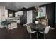Stylish dining area and kitchen featuring a dark accent wall, modern lighting, and a chef's kitchen in an open layout at 5725 N Conquistador St, Las Vegas, NV 89149