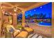 Cozy back patio with lounge chairs, ceiling fan and outdoor lighting, overlooking the pool at night at 6206 Rio Camuy Ave, Las Vegas, NV 89131