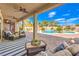 Covered back patio with ceiling fans, cozy seating, and a view of the pool and well-maintained backyard at 6206 Rio Camuy Ave, Las Vegas, NV 89131