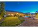 Lush backyard with manicured lawn, desert landscaping, covered patio, pool, and spa during blue hour at 6206 Rio Camuy Ave, Las Vegas, NV 89131