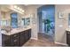 Bathroom featuring a double vanity with marble countertops, wood-look tile flooring, and an arched entryway at 6206 Rio Camuy Ave, Las Vegas, NV 89131