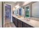 Bright bathroom showcasing a double vanity with marble countertops and views into adjacent rooms at 6206 Rio Camuy Ave, Las Vegas, NV 89131
