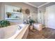 Bright bathroom showcasing a soaking tub, separate glass shower, and decorative shelving with accent pieces at 6206 Rio Camuy Ave, Las Vegas, NV 89131