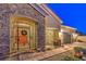 Beautiful stone-accented entryway with iron gate at twilight leading to the home's double front doors and garage at 6206 Rio Camuy Ave, Las Vegas, NV 89131