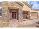Close up of beautiful stone-accented entryway with an iron gate, a double front door, and a three-car garage at 6206 Rio Camuy Ave, Las Vegas, NV 89131