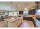 Open kitchen boasts a large island, dark wood cabinets, granite counters, and stainless steel appliances at 6206 Rio Camuy Ave, Las Vegas, NV 89131