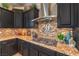 Close-up of a modern kitchen featuring granite countertops, tiled backsplash, and stainless steel appliances at 6206 Rio Camuy Ave, Las Vegas, NV 89131