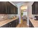 Spacious kitchen with dark wood cabinets, granite counters, tile backsplash, and a view into the dining room at 6206 Rio Camuy Ave, Las Vegas, NV 89131
