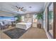 Bright main bedroom featuring a ceiling fan, seating area, coastal decor, and access to a private balcony at 6206 Rio Camuy Ave, Las Vegas, NV 89131