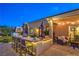 Backyard patio with outdoor kitchen at twilight featuring bar seating and lounge chairs at 6206 Rio Camuy Ave, Las Vegas, NV 89131