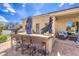Outdoor kitchen with a bar, built-in grill, and seating area, perfect for entertaining in the backyard at 6206 Rio Camuy Ave, Las Vegas, NV 89131