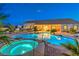 Backyard pool and spa with underwater lighting, lush landscaping, and covered patio of the home at dusk at 6206 Rio Camuy Ave, Las Vegas, NV 89131