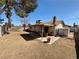 Wide view of the backyard featuring a covered patio, mature landscaping, and a cozy outdoor dining area at 6412 Churchfield Blvd, Las Vegas, NV 89103
