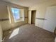 This bedroom has neutral walls, a standard closet, carpet, and a window at 6412 Churchfield Blvd, Las Vegas, NV 89103