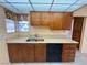 This kitchen has a dual stainless sink, wood cabinets, and black appliances at 6412 Churchfield Blvd, Las Vegas, NV 89103